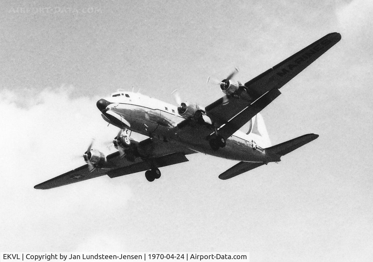 EKVL Airport - Douglas C-54 of US Marines seen on final approach to Runway 28 at Vaerloese Air Base in Denmark in 1970. The plane had a red marking on the vertical stabilizer and the oval cabin windows were painted square.